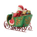 Figurine of Santa in a decorative sleigh with bags of gifts on a white background