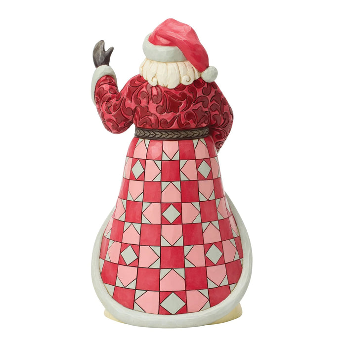 Santa Claus figurine with a book and Carolers scene on a white background