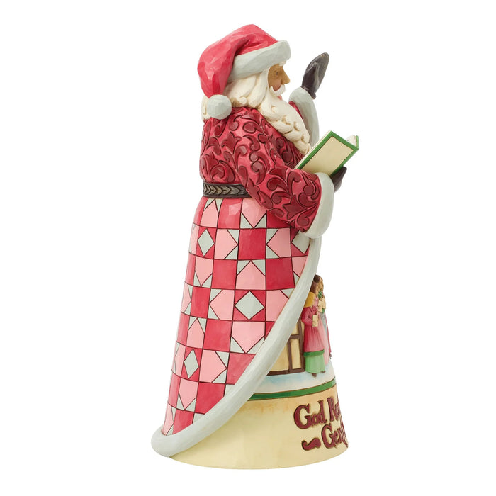 Santa Claus figurine with a book and Carolers scene on a white background