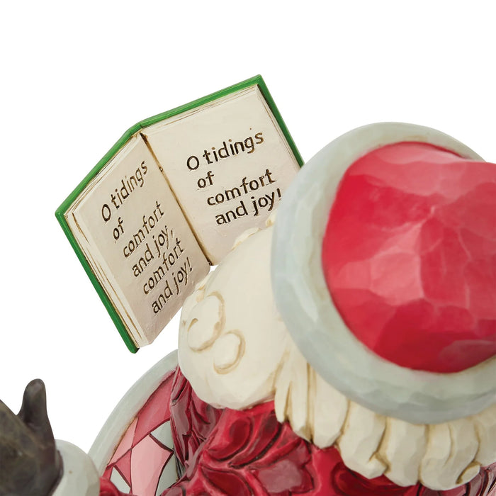 Santa Claus figurine with a book that says "O tidings of comfort and joy, comfort and joy! O tidings of comfort and joy!"