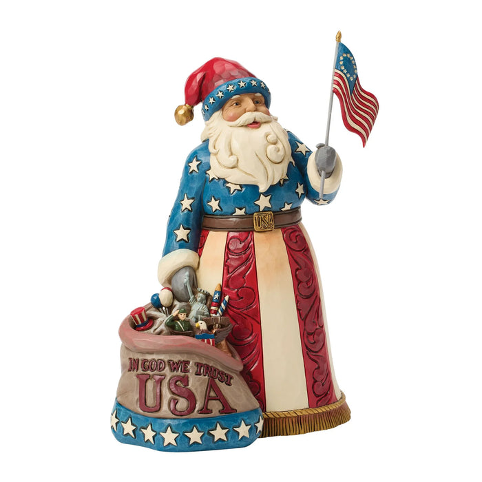 Decorative figurine of a patriotic Santa Claus holding an American flag on a white background
