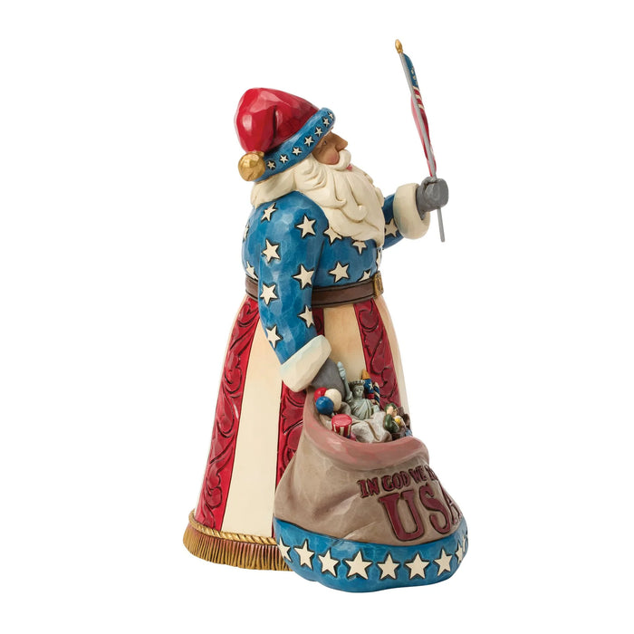 Decorative figurine of a patriotic Santa Claus holding an American flag on a white background