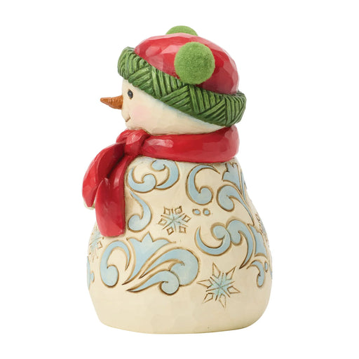 Decorative snowman figurine with a green hat and red scarf on a white background