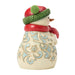Decorative snowman figurine with a red scarf and green hat on a white background