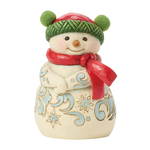 Decorative snowman figurine with a red scarf and green hat on a white background