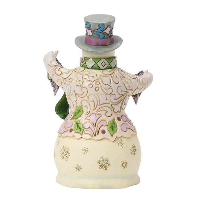 A decorative ceramic snowman figurine with a cream-colored body, gold glitter patterns, green and purple accents, and a gray top hat, shown against a plain white background.