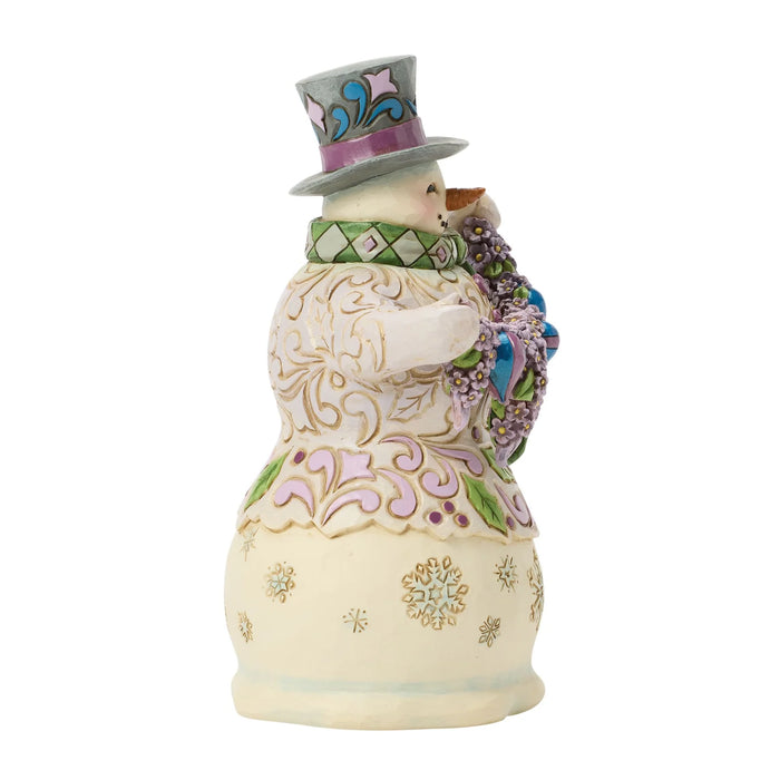 Decorative figurine of a snowman with a top hat and floral wreath on a white background