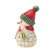 Snowman figurine with red and green hat and scarf holding a bell on a white background