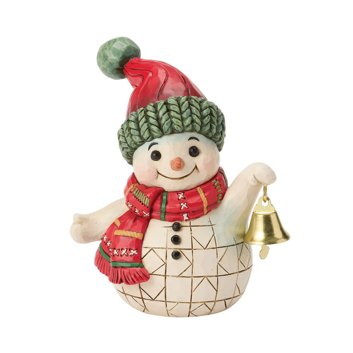 Snowman figurine with red and green hat and scarf holding a bell on a white background