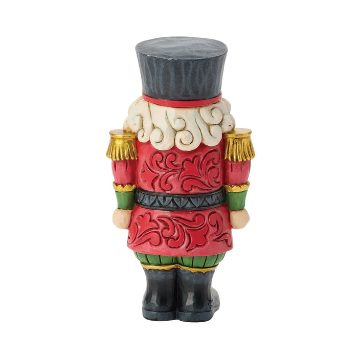 Mini festive Santa nutcracker figurine on a white background