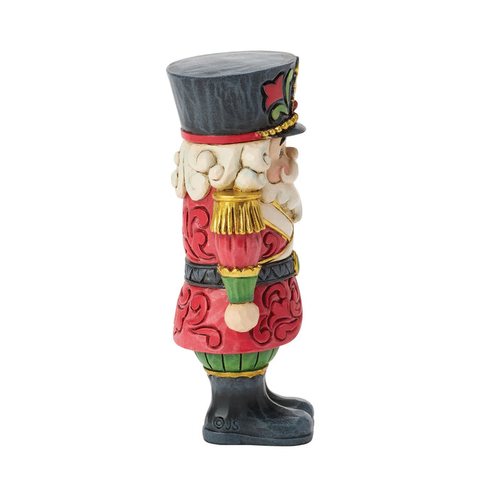 Mini festive Santa nutcracker figurine on a white background
