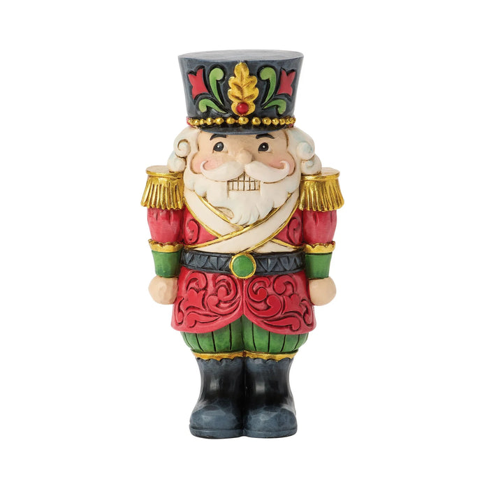 Mini festive Santa nutcracker figurine on a white background