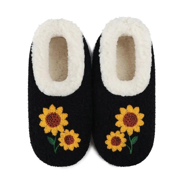 A pair of black slip-on slippers with white sherpa lining and embroidered yellow sunflowers on the front, shown against a plain white background.