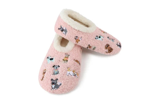 A pair of pink fleece slip-on slippers with a cream sherpa lining and an all-over print of small dog illustrations, shown on a plain white background.