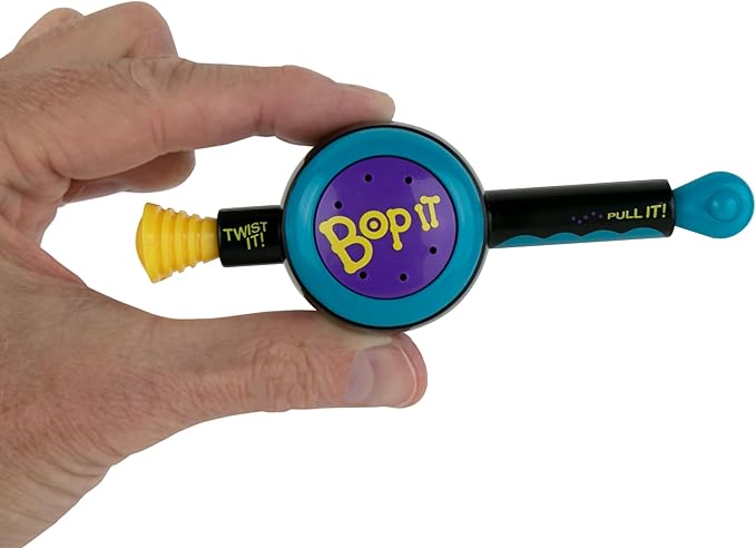 Hand holding a colorful 'Bop It!' electronic game device on a white background