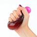 Hand holding a purple and brown stress ball against a white background