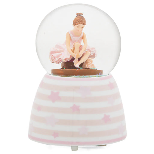 Glowing snow globe with a ballerina figure on a striped base