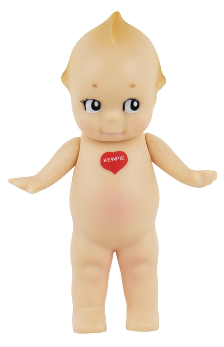 A vintage-style plastic baby doll with a pale peach skin tone, large dark eyes, and a small red heart-shaped badge on the chest that reads 'KEMPIE'.