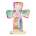 Colorful cross-shaped object with floral design on a white background