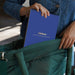 Person holding a blue notebook titled 'Lifelines' with a green chair in the foreground