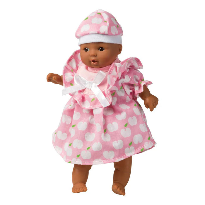 Doll wearing a pink outfit with white polka dots on a white background