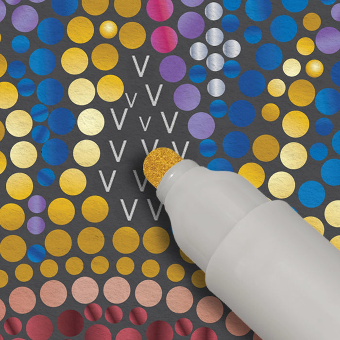 Decorative paper with colorful polka dots and a white glue stick applying glue.