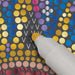 Decorative paper with colorful polka dots and a white glue stick applying glue.