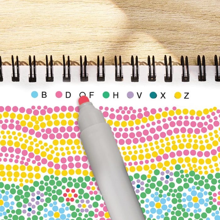 Color swatch book with a pen on a wooden surface