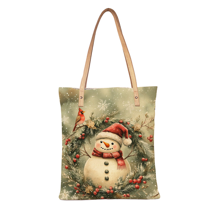 Tote bag with a Christmas design featuring a snowman, cardinal, and winter elements on a white background.