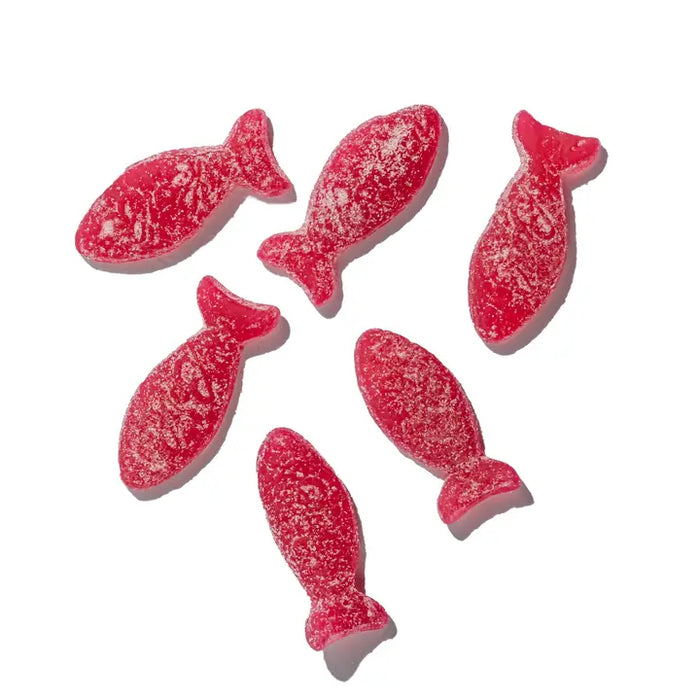 Red fish-shaped gummy candies on a white background