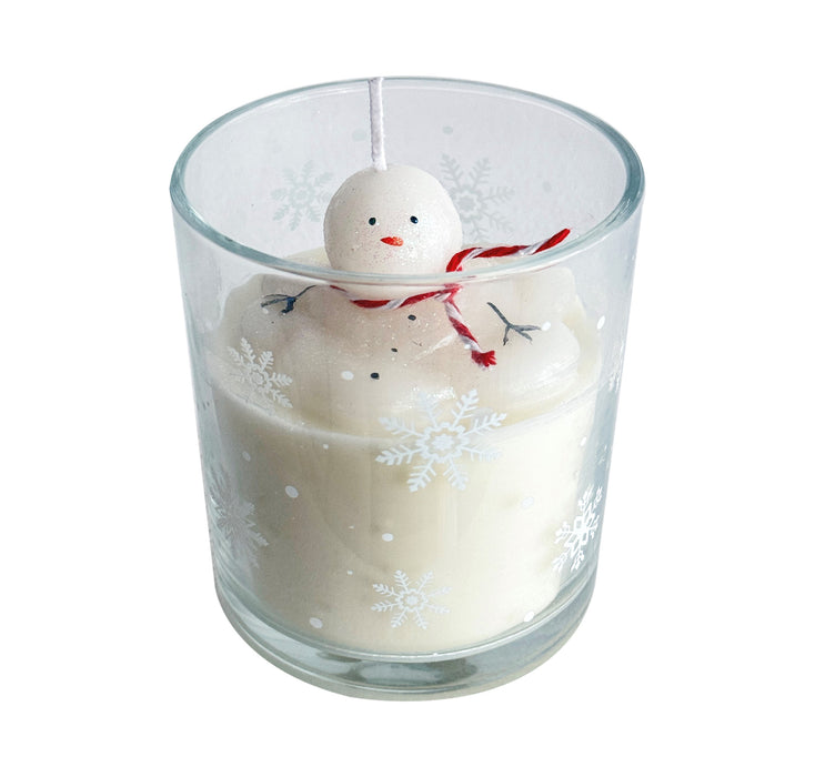 Candle in a glass holder with a snowman decoration on a white background