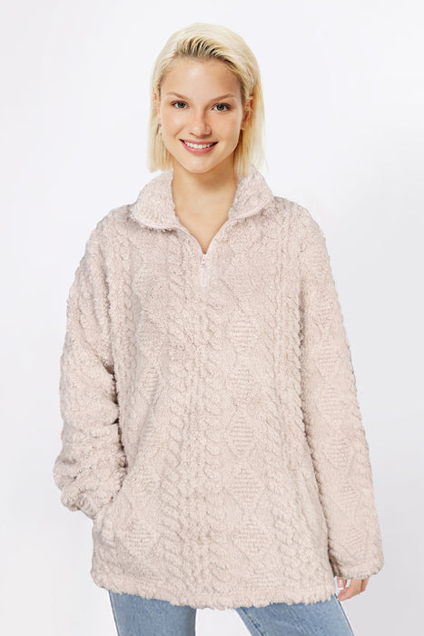 Woman wearing a beige fleece pullover against a white background