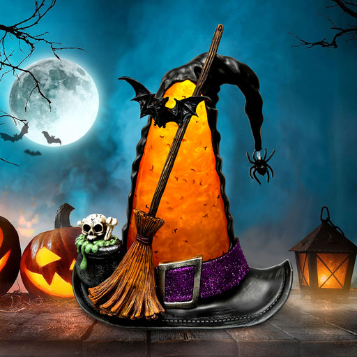 A Halloween-themed witch hat shaped like a pumpkin, glowing orange with a black brim, purple glitter band, broom, bat, spider, skull, and jack-o'-lanterns against a full moon night sky.