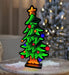 Decorative Christmas tree light on a wooden surface with a blurred festive background.