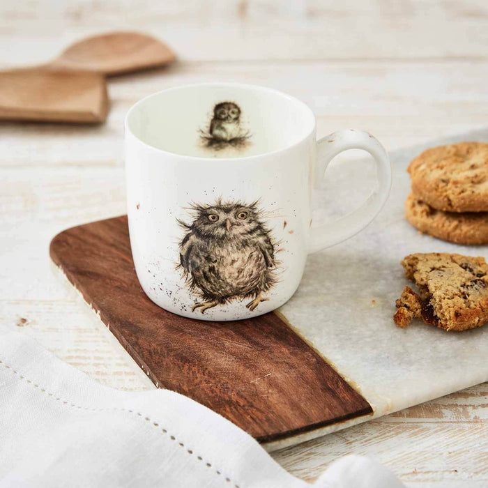 White mug with owl design on a marble surface with cookies