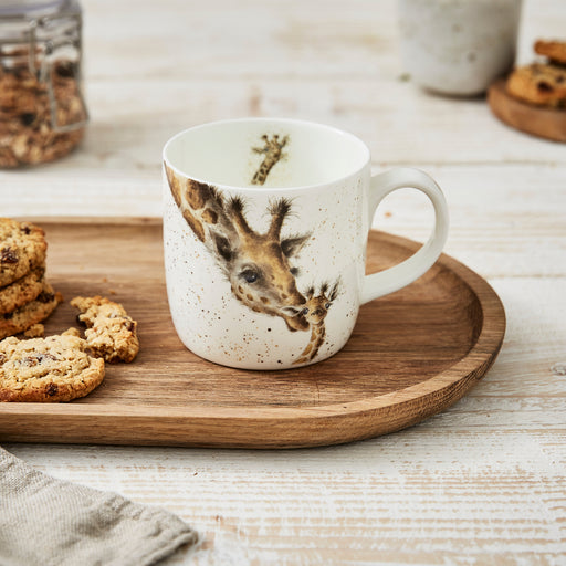 White mug with giraffe design on a wooden tray with cookies