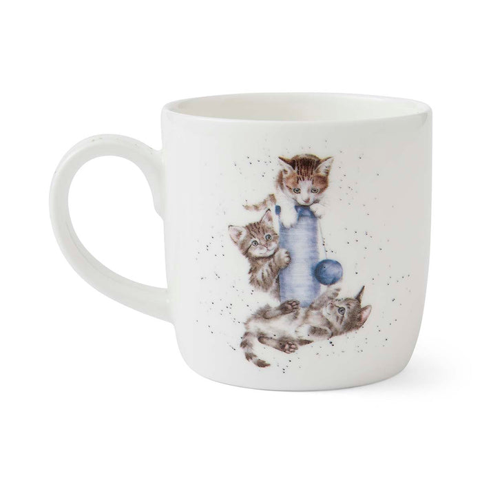 White mug with a design of three kittens playing with a yarn ball on a white background