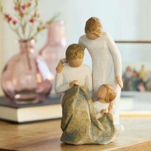 Statue of a family on a table with decorative vases in the background
