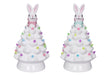 Two ceramic Christmas trees with bunny figures on top against a white background