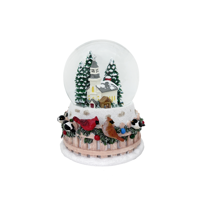 Christmas-themed snow globe with trees, house, and birds on a white background