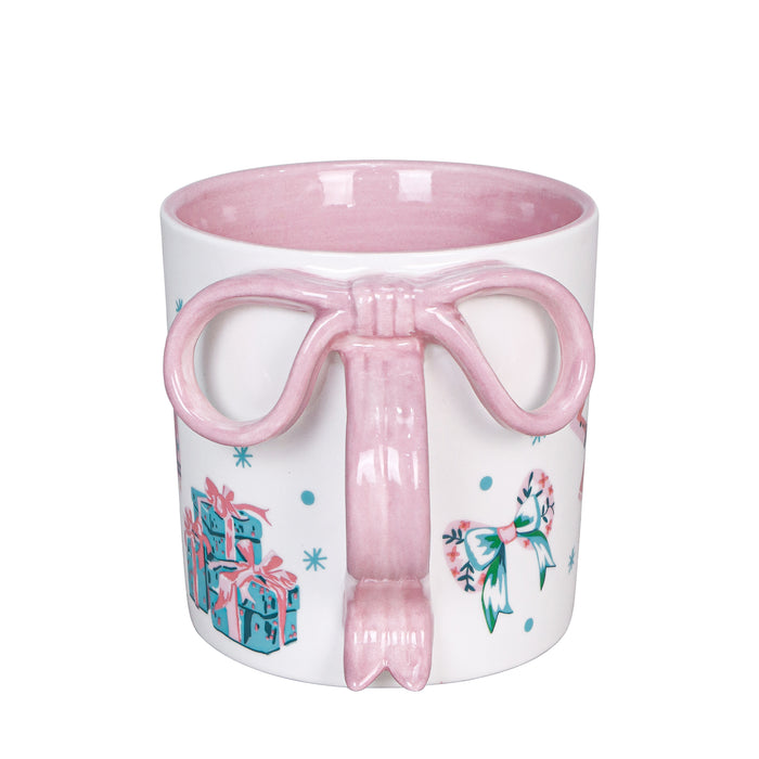 White mug with pink bow handle and festive design on a white background