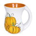 White mug with orange interior, handle, and pumpkin design on a white background