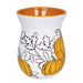 Ceramic mug with orange interior, white exterior, and black and orange pumpkin design on a white background