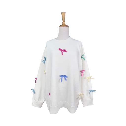 White sweater with colorful bow designs on a mannequin against a white background