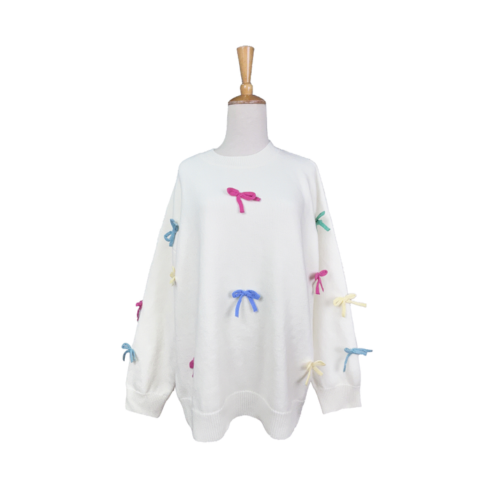 White sweater with colorful bow designs on a mannequin against a white background