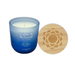 Blue candle labeled 'Calm & Relaxed Ocean Mist' with a wooden lid on a white background