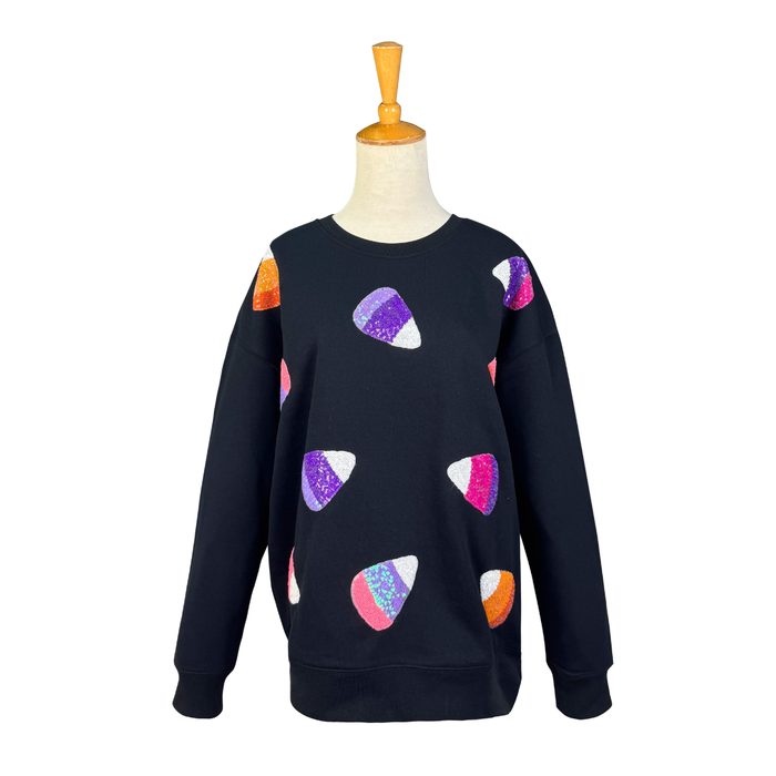 A black crewneck sweatshirt displayed on a mannequin torso, featuring colorful sequined guitar pick motifs in purple, pink, orange, and white across the front.