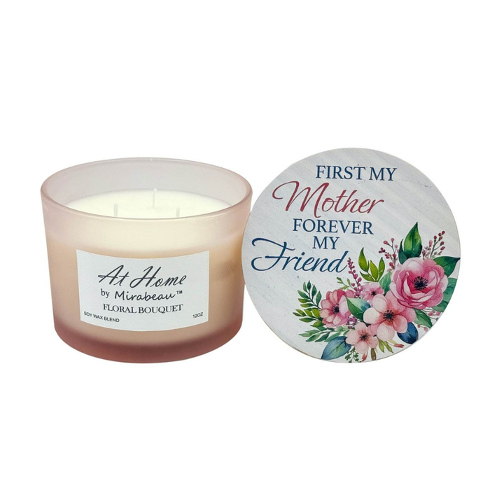 Candle with a decorative lid featuring floral designs and text.