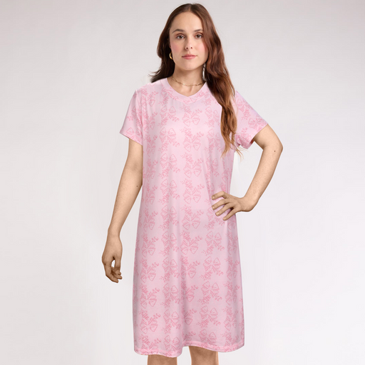 Woman wearing a pink floral dress against a plain background