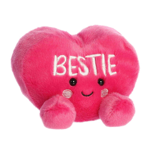 Pink plush heart-shaped toy with 'BESTIE' text on a white background